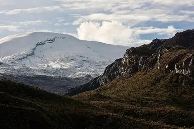 a mountain with a snow covered mountain in the distance at Habitación privada in Manizales
