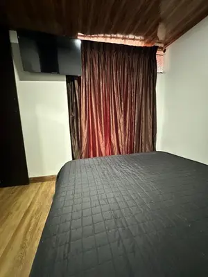 a bed in a room with a red curtain at Habitación privada in Manizales