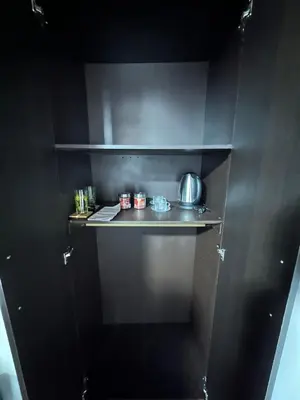 a black kitchen with a shelf with pots and pans at Habitación privada in Manizales