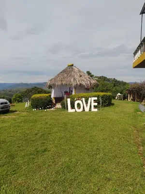 a sign that says love sitting in a grass field at Camping San Gabriel in Angostura