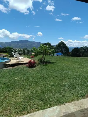 a lawn with a bench and a view of mountains at Camping San Gabriel in Angostura