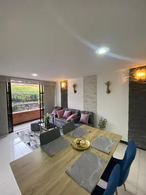 a living room with a table and a couch at Apartamento Cozy in Medellín