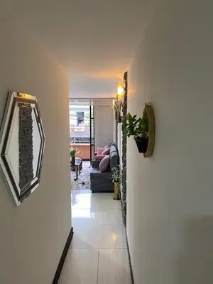 a hallway leading to a living room with a couch at Apartamento Cozy in Medellín