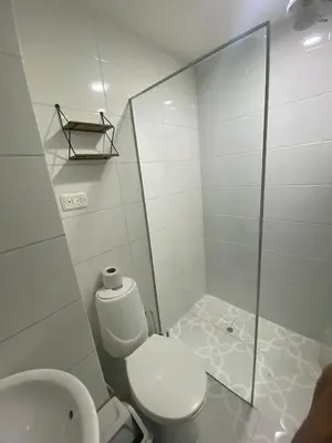 a white bathroom with a toilet and a sink at Apartamento Cozy in Medellín