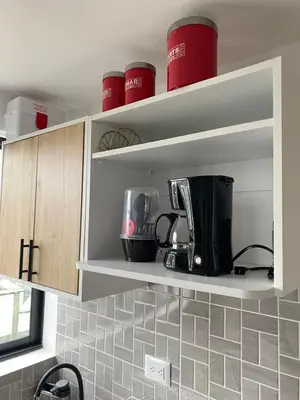 a kitchen with red cups on the shelves at Apartaestudio Calle 51, Avenida Santander in Manizales