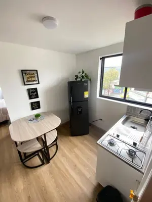 a small kitchen with a stove and a small table at Apartaestudio Calle 51, Avenida Santander in Manizales