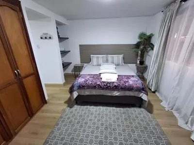 a bedroom with a large bed in a room at Apartaestudio Calle 51, Avenida Santander in Manizales