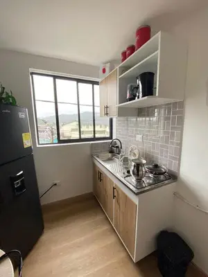 a kitchen with a sink and a stove top oven at Apartaestudio Calle 51, Avenida Santander in Manizales
