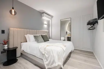 a white bedroom with a bed and a staircase at Nago Hometel Boutique in Medellín