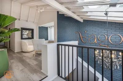 a living room with a staircase and blue brick wall at Nago Hometel Boutique in Medellín