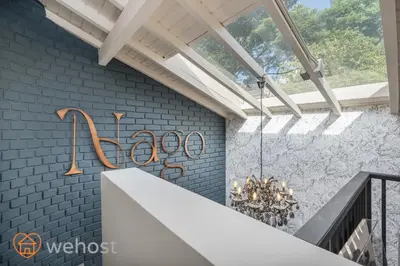 a staircase with a chandelier and a blue brick wall at Nago Hometel Boutique in Medellín