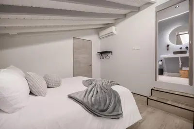 a bedroom with a white bed with a blanket on it at Nago Hometel Boutique in Medellín