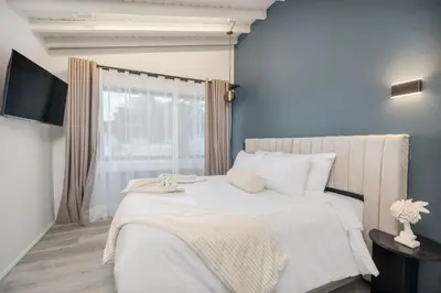 a bedroom with a white bed and a window at Nago Hometel Boutique in Medellín