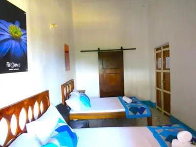 a bedroom with two beds and a door at Casa Fibonacci in Titiribí