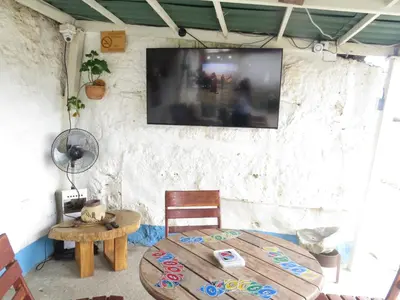 a room with a table and a tv on a wall at Casa Fibonacci in Titiribí
