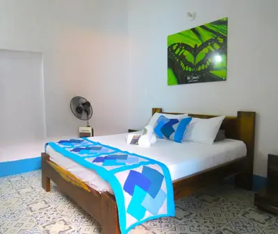 a bedroom with a bed and a fan at Casa Fibonacci in Titiribí