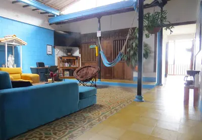 a living room with a blue couch and a hammock at Casa Fibonacci in Titiribí