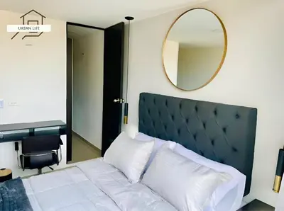 a bedroom with a large bed and a mirror at Urbanlifestudios in Medellín