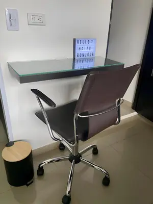 a desk with a chair with a glass top at Urbanlifestudios in Medellín