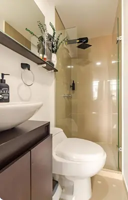 a bathroom with a toilet and a glass shower at Urbanlifestudios in Medellín