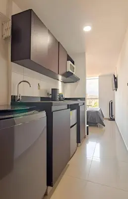 a kitchen with black and white cabinets and a sink at Urbanlifestudios in Medellín