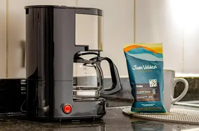 a coffee maker sitting on a counter next to a cup at Urbanlifestudios in Medellín