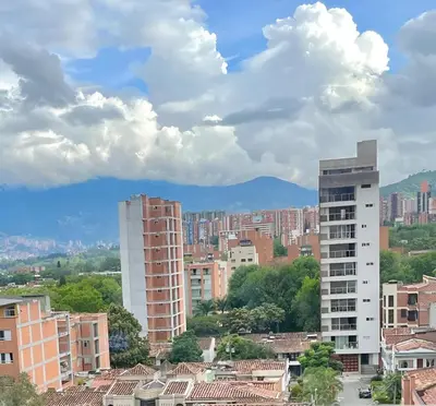 a city with buildings and mountains in the background at Urbanlifestudios in Medellín