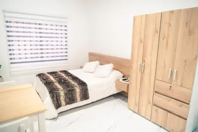 a bedroom with a bed and a wooden cabinet at Aparta estudio 205- Casa Bendita in Medellín