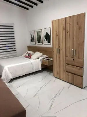 a bedroom with two beds and a large wooden cabinet at Aparta estudio 205- Casa Bendita in Medellín