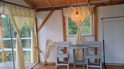 a room with a table and two chairs and windows at Chalet Campestre San Gabriel in Angostura