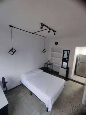 a white room with a bed and a light at Espectacular Aparta estudio Laureles in Medellín