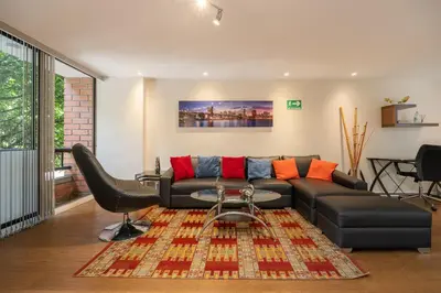 a living room with a couch and a table at Apartamentos Ayamonte by HOUSY HOST in Medellín