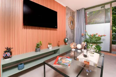 a living room with a table and a tv on a wall at Apartamentos Ayamonte by HOUSY HOST in Medellín
