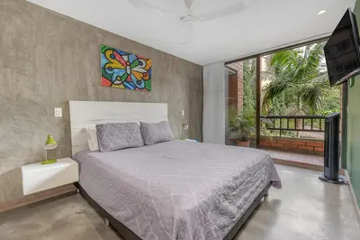 a bedroom with a bed and a tv in it at Apartamentos Ayamonte by HOUSY HOST in Medellín
