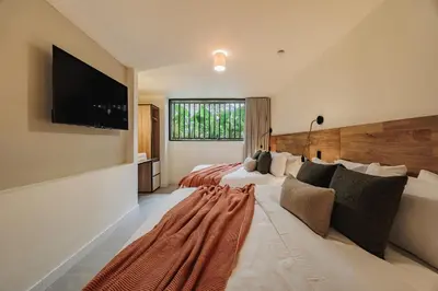 a large bedroom with two beds and a flat screen tv at 10A House Pool Provenza in Medellín
