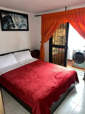 a bedroom with a bed with a red blanket at Apartamento Barrio la Argentina vía principal 302 in Manizales