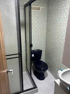 a bathroom with a black toilet and a sink at Apartamento Barrio la Argentina vía principal 302 in Manizales