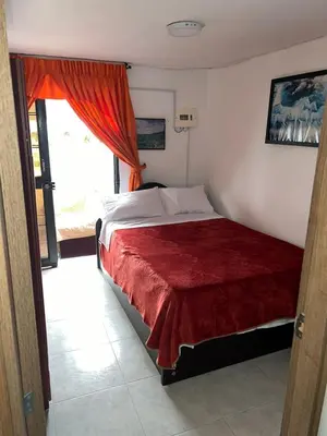 a bedroom with a bed with a red blanket at Apartamento Barrio la Argentina vía principal 302 in Manizales