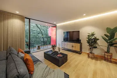 a living room with a couch and a flat screen tv at Exquisito Estudio en Provenza in Medellín