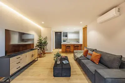 a living room with a couch and a flat screen tv at Exquisito Estudio en Provenza in Medellín