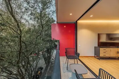 a room with a red wall and a table and chairs at Exquisito Estudio en Provenza in Medellín