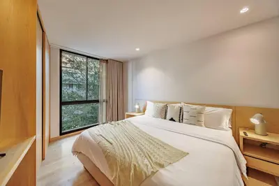 a bedroom with a large white bed and a window at Exquisito Estudio en Provenza in Medellín