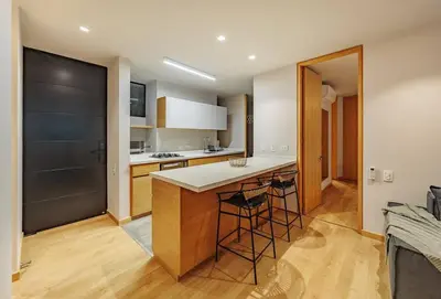 a kitchen with a counter and some stools at Exquisito Estudio en Provenza in Medellín