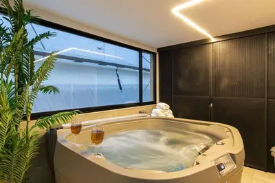 a large tub in a bathroom with two glasses of wine at Surprising, Lleras Park, Billar Pool And Jacuzzi in Medellín