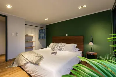 a bedroom with a large bed with a green wall at Surprising, Lleras Park, Billar Pool And Jacuzzi in Medellín