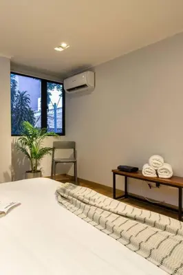 a bedroom with a bed with a desk and a window at Surprising, Lleras Park, Billar Pool And Jacuzzi in Medellín