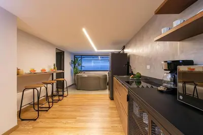 a kitchen with a counter and stools in it at Surprising, Lleras Park, Billar Pool And Jacuzzi in Medellín