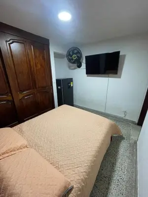 a bedroom with a bed and a flat screen tv at El Descanso in Rionegro