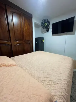 a bedroom with a bed and a flat screen tv at El Descanso in Rionegro