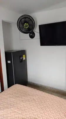 a bedroom with a black refrigerator and a fan at El Descanso in Rionegro